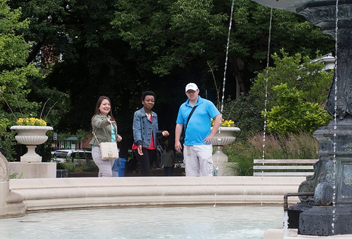 A Greeter and two visitors near a fountain in Chicago’s Wicker Park neighborhood.